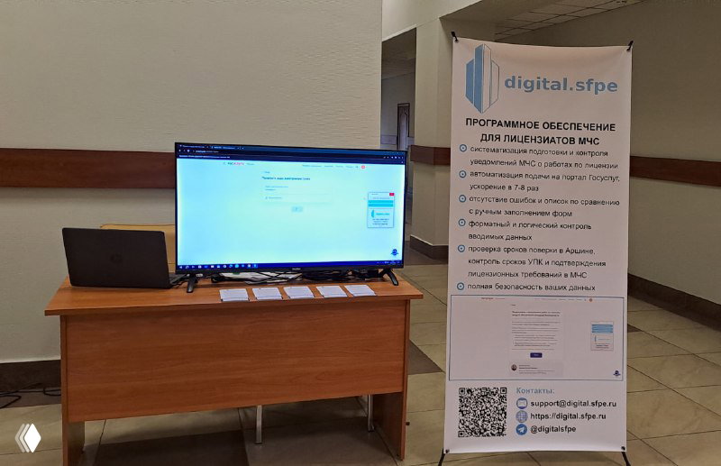Выставочный стенд ПО digital.sfpe: стол с ноутбуком и монитором, рядом роллап с описанием продукта и QR‑кодом для контактов и демонстраций.
