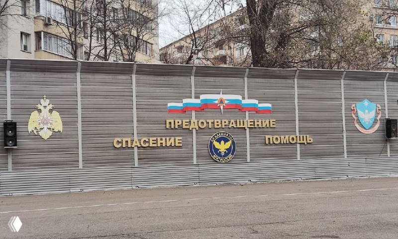 Наружная стена с гербами и надписями «Предотвращение. Спасение. Помощь» на территории Академии МЧС, вид со стороны улицы рядом с местом проведения.