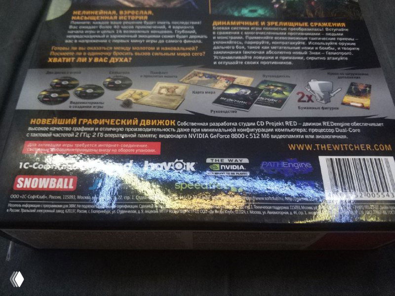 Крупный план тыльной стороны коробки с перечислением дисков, логотипами и технической информацией; заметны отражения света на лакированной поверхности.