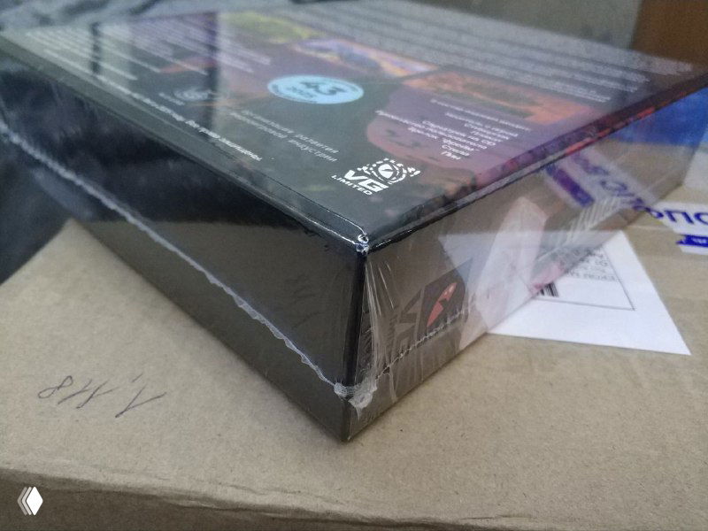 Крупный план угла коробки «Периметр Legate Edition» в плёнке на картонной упаковке, видны швы, крепление и мелкие следы при хранении/транспортировке.