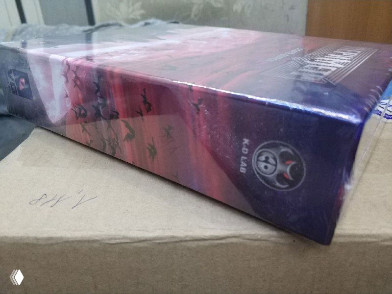 Боковая грань коллекционного издания Perimeter в заводской плёнке на фоне полиэтиленового пакета; заметны элементы оформления боковой панели и логотипы.