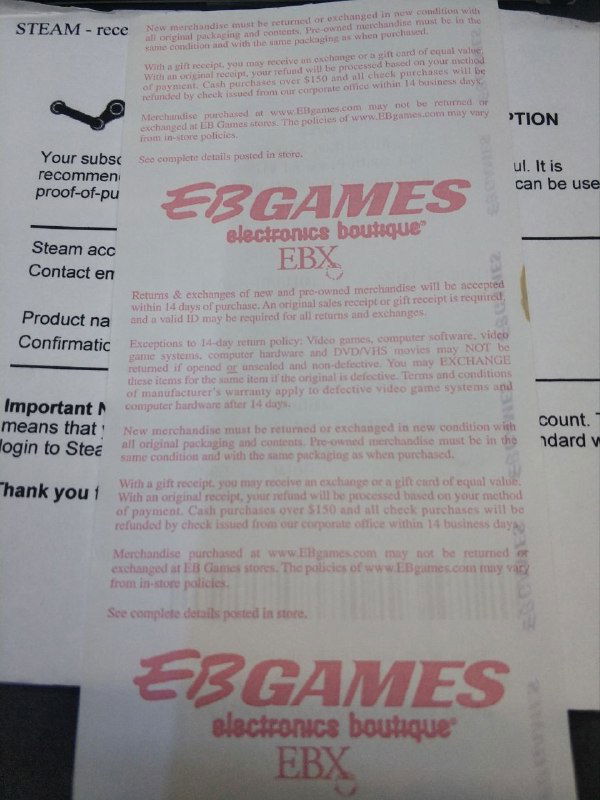 Крупный план чека с логотипом EB Games и красной печатью; заметно сильное выцветание термопечати и частичная потеря читаемости текста.