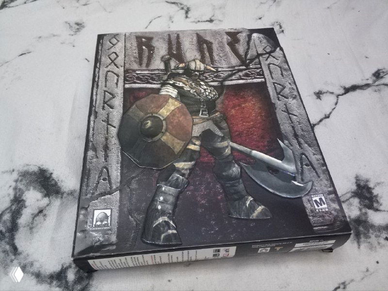 Фотография лицевой стороны коробки Rune с изображением викинга и щита; видны потертости, рельефная печать и общее оформление коробки.