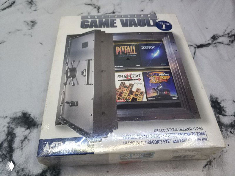 Фотография лицевой стороны Activision Game Vault volume 1 в запечатанном виде; виден рисунок сейфа и анонс игр на передней панели коробки.
