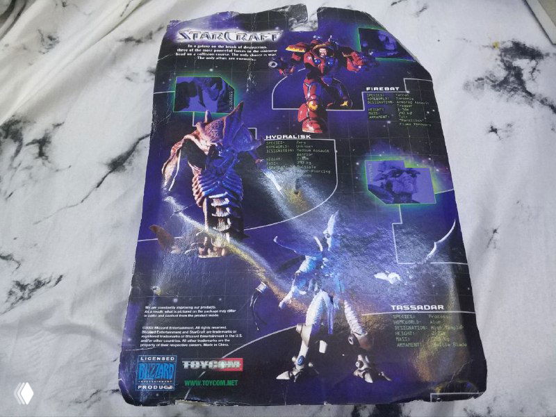 Обратная сторона картонной вкладки упаковки StarCraft Series One с иллюстрацией и информацией о юните; картон помят и частично оторван сверху.