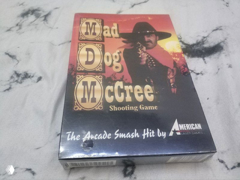 Лицевая сторона коробки Mad Dog McCree (American Laser Games) — ковбойская обложка, название игры и стилистика аркадного FMV-шутера.