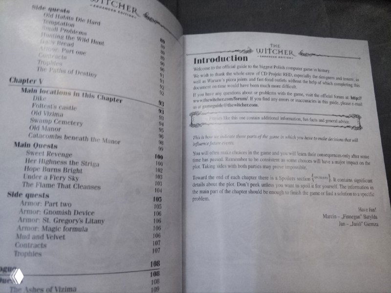 Открытая страница руководства The Witcher: разворот с оглавлением и вступлением, текст на английском и пометки на полях.