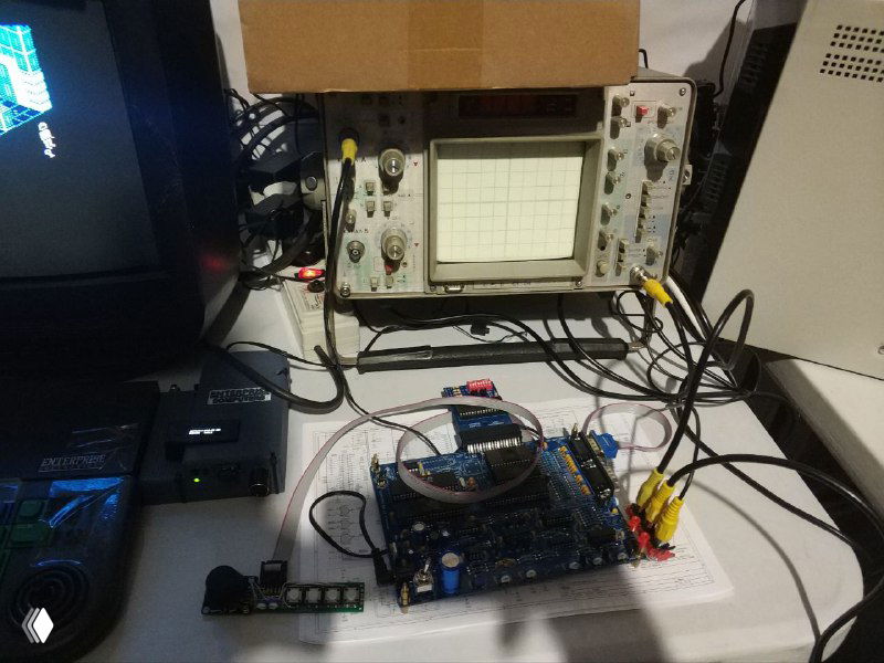 Стенд с платой и осциллографом: плата с проводами, видеовыходами и подключённый осциллограф на заднем плане; рабочая зона выставки с инструментами и кабелями.