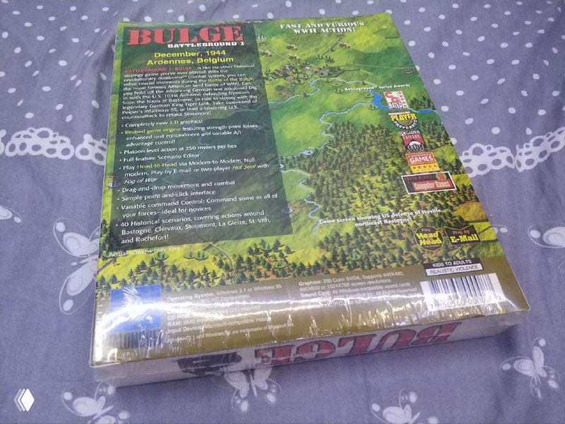 Обратная сторона коробки Battleground 1: Bulge с превью геймплея, описанием и техническими данными; коробка в плёнке, снимок вблизи.