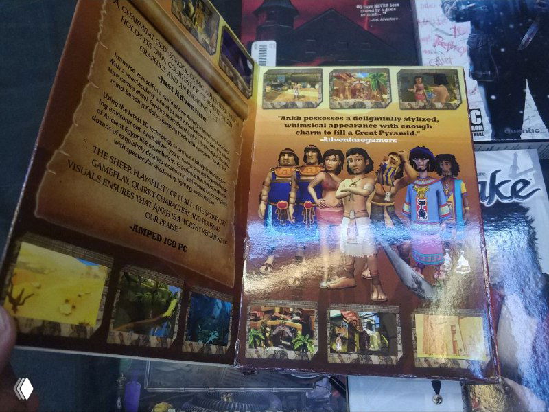 Разворот издания с иллюстрациями и текстом (Ankh): видна внутренняя вклейка с цветными кадрами и бликами глянца.