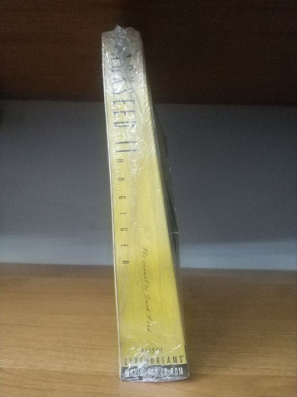 Боковой вид узкой нестандартной коробки Dark Seed II для MacOS, демонстрирующий её сужающуюся к верху форму и высоту упаковки.