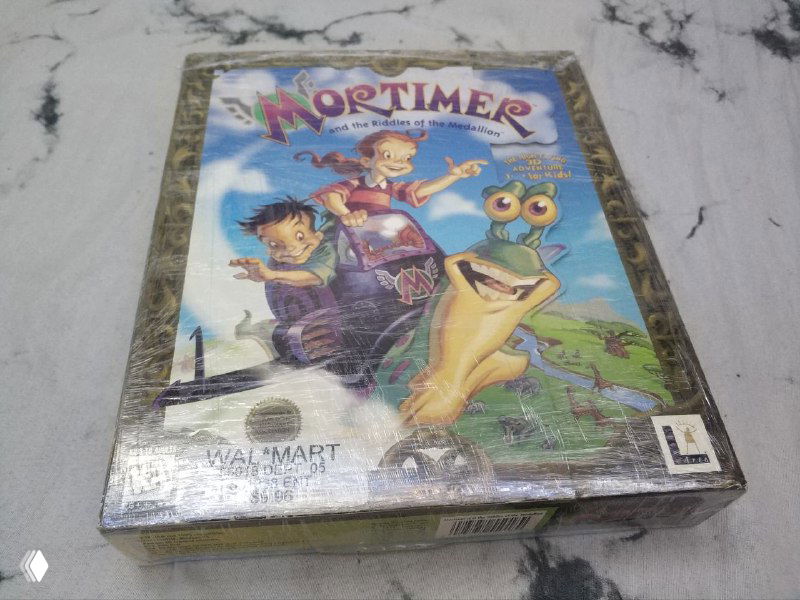 Передняя сторона коробки Mortimer (1996, LucasArts), запечатанное розничное издание с яркой иллюстрацией персонажей и блеском плёнки.