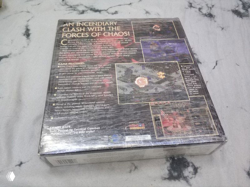 Задняя сторона коробки Warhammer 40000 — Chaos Gate с описанием геймплея и скриншотами, хранится запечатанной и снята на светлом фоне.
