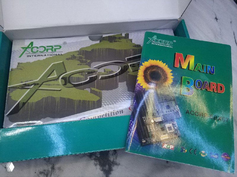 Открытая коробка и сопроводительный вкладыш/мануал Acorp рядом с крышкой; видна внутренняя графика упаковки и полиграфия винтажного комплекта.