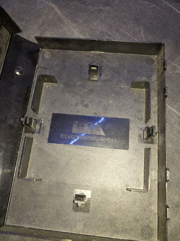 Внутренняя сторона коробки картриджа Desert Strike: вид отсека для картриджа и креплений, видна конструкция обратного трилиста без вставленного картриджа.