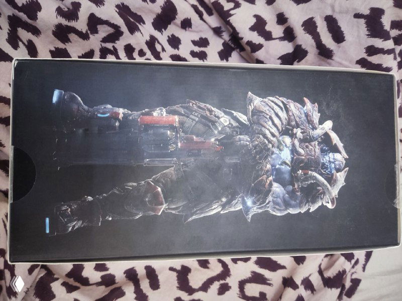 Ещё одна фотография боковой панели упаковки с крупным изображением фигурки Scalebearer на чёрном фоне — вид упаковки под другим углом.