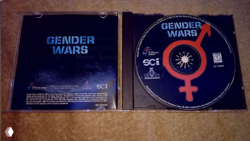Открытый кейс с компакт-диском Gender Wars и логотипом SCi, видна внутренняя печать и оформление лицевой стороны диска.