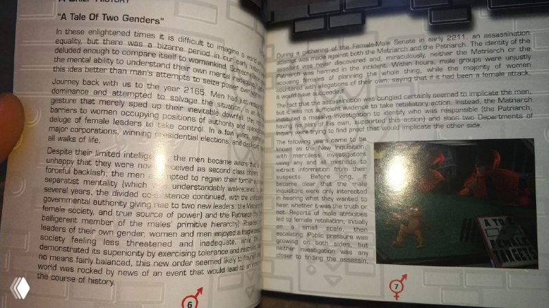 Разворот мануала Gender Wars с плотным английским текстом и небольшим игровым скриншотом в правой части, видна рука, держащая книгу.