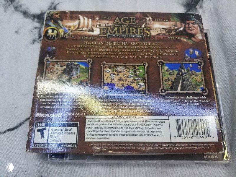 Задняя сторона большой коллекционной коробки Age of Empires: иллюстрации игрового процесса, блоки текстов с описанием и штрих-код на нижней части упаковки.