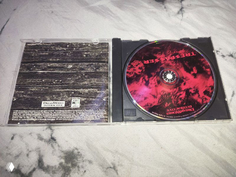 Открытый бокс с диском и внутренней частью коробки джевел‑издания Trespasser; виден красно‑чёрный диск с графикой и текстовые вставки на вкладыше.