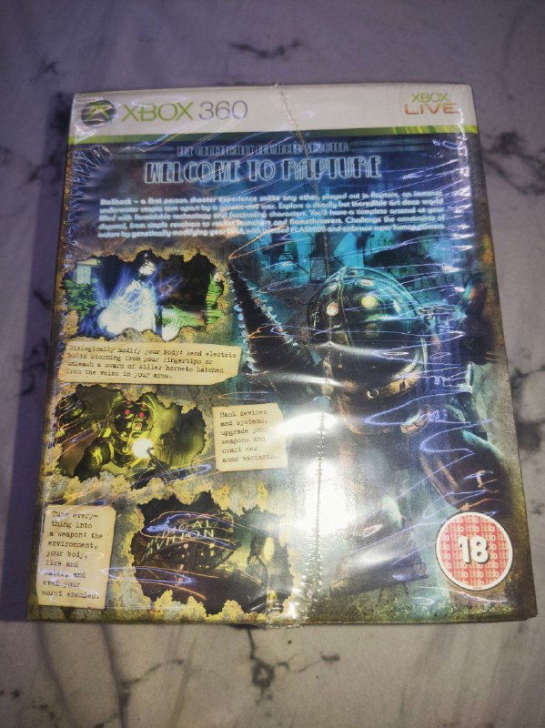 Задняя сторона коробки издания Bioshock Collector's Edition со списком контента и иллюстрациями на глянцевом фоне, пакет ещё не вскрыт.