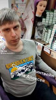 Сцена в парикмахерской: клиент/модель и манекен на фоне полок с упаковками, реальная рабочая обстановка и визуальные элементы Reels.