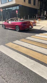 Вертикальный кадр с красным кабриолетом на зебре у магазина: уличная сцена, используемая как «реальное» видео для посева в Telegram.