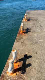 Кадр с пирсом и морской водой: стоп-кадр с причалом и металлическими швартовами, создающий атмосферу «снимали случайно» в ролике.