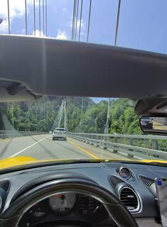 Дорожный кадр с открытым верхом автомобиля: вид на дорогу и окружающий пейзаж в стиле путешествия, съёмка через очки в движении.