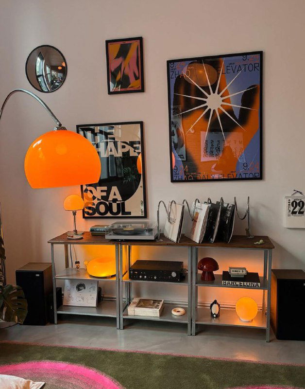 Настенная композиция из плакатов над системой хранения и лампой: фото демонстрирует как плакаты вписываются в домашний декор.