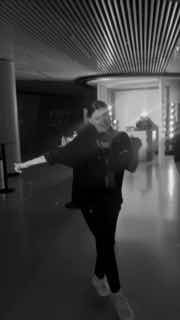 Чёрно‑белый вертикальный фрагмент видео с человеком, делающим экспрессивное движение на фоне интерьера — динамичный элемент рилса для усиления истории бренда.