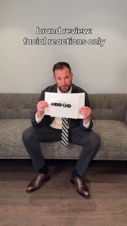 Фотография человека в костюме, держащего лист с надписью 'HBO GO' — шутливый брендовый ревью в формате короткого видео и мемов о ребрендинге.