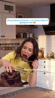 Женщина на кухне энергично ест большой кусок торта — мемный клип, показывающий ироничный и гиперболизированный пищевой контент.