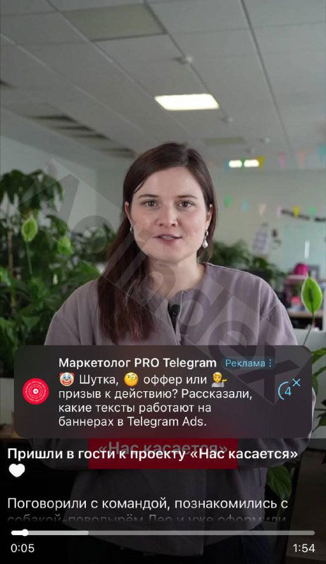 Кадр с женщиной в офисной обстановке; на видео заметен интерфейс Telegram и пример текстового рекламного баннера внизу экрана.
