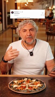 Крупный план: мужчина за столом рядом с тарелкой пиццы, он рассказывает о запуске новой позиции в меню ресторана, эмоциональная подача в ролике.