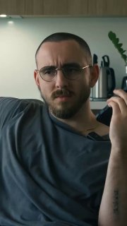 Мужчина в очках разговаривает по телефону в офисном интерьере — кадр из ролика про работу в маркетинге и взаимодействие с клиентами.