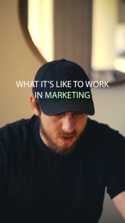 Крупный план мужчины в кепке во время записи вертикального видео с наложенным текстом про работу в маркетинге — атмосферный сторис-стиль.