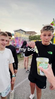 Рука протягивает банку Grillo's Pickles подростку на уличном фестивале; на заднем плане люди и атмосфера офлайн-ивента, подпись в ролике.