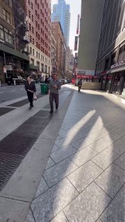 Вертикальный уличный кадр большого города с людьми на тротуаре и архитектурой — контекст съёмки Reels и перенос продукта в городской поток.