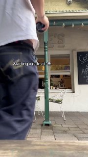 Уличный кадр у входа в кофейню: часть фасада, столики и вывеска, кадр вертикального видео с подписью о старте кафе в 18 лет.