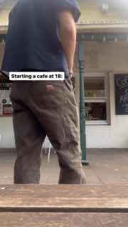 Кадр снизу показывающий ноги и корпус человека у улицы перед кафе — повседневная сценка в вертикальном видео о начале деятельности.