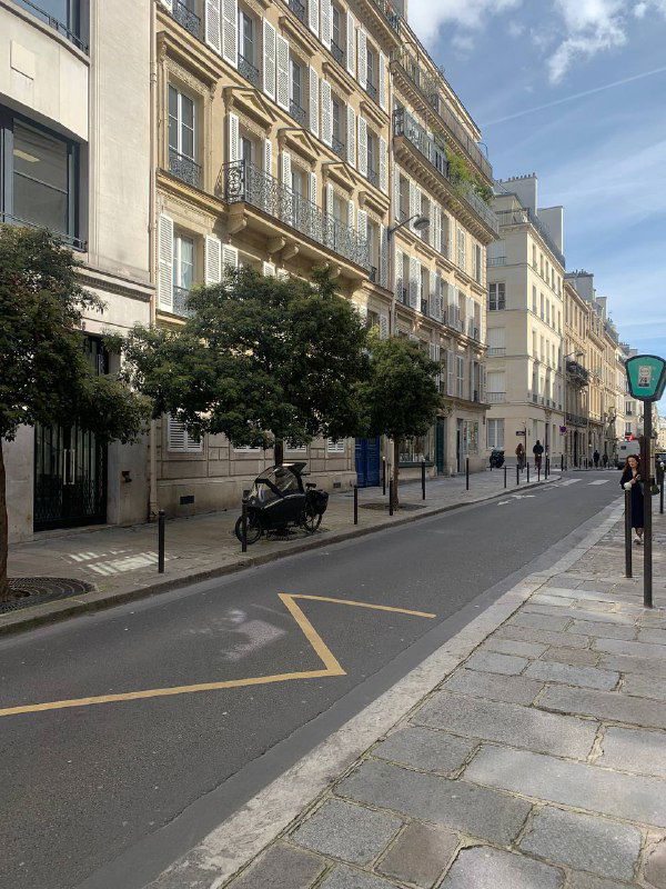 Уличная инсталляция или арт-объект на пешеходной площади, посреди людей в солнечный день — красочный городской декор весны в Париже.