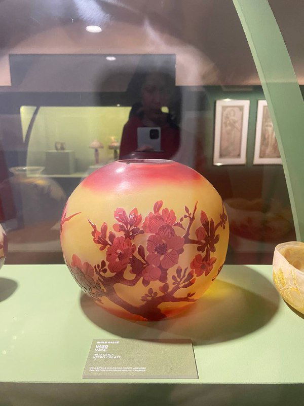 Крупный план расписной стеклянной вазы с растительным орнаментом в витрине — деталь коллекции ар‑нуво в Museo degli Innocenti.