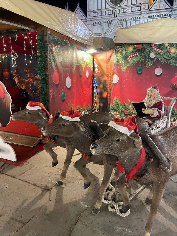 Декоративные олени и санки в витрине рождественской площадки: инсталляция с праздничными фигурами для фотозон посетителей рынка.