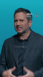 Кадр из видеоурока: человек в тёмном пиджаке на бирюзовом фоне с логотипом BBVA; иллюстрация урока по произношению