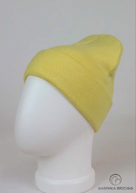 Пастельно‑жёлтая базовая шапка на манекене, студийная фотография демонстрирует цвет и плотность вязки для оформления карточки товара.