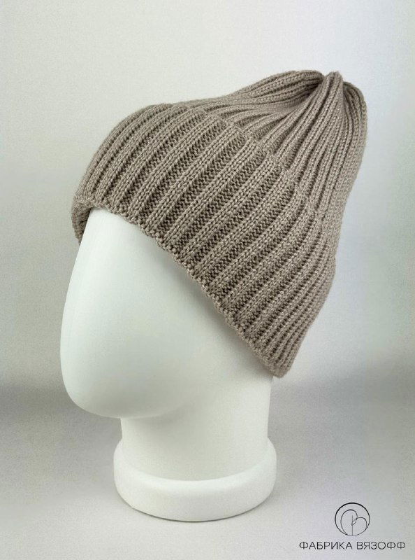 Бежевая вязаная шапка на манекене в крупном плане; виден состав полотна и аккуратная форма с небольшим отворотом, светлый фон.