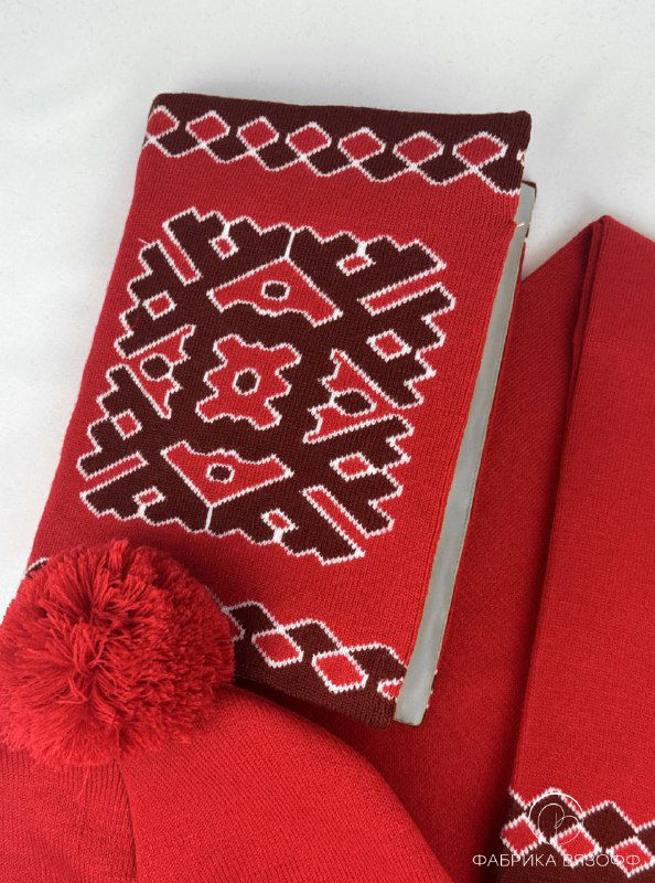 Обложка ежедневника с вышитоподобным национальным мотивом рядом с шапкой с помпоном — детализация узора и отделки.