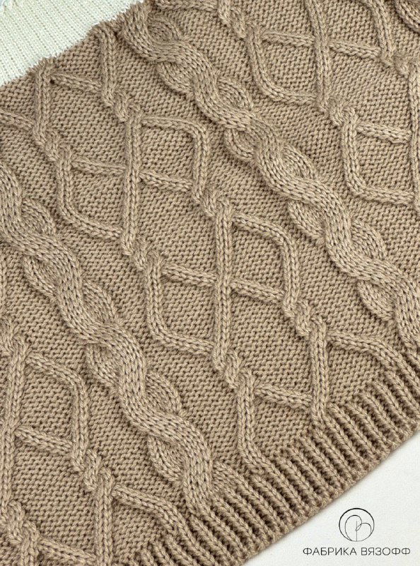 Участок полотна с переплетающимися косами и открытыми дорожками, бежевый оттенок пряжи подчёркивает рельеф рисунка.