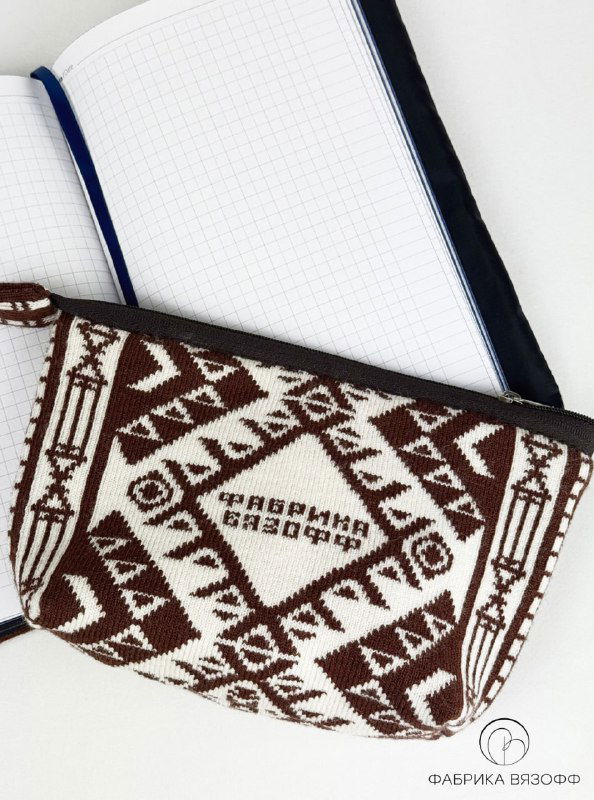 Косметичка с темно-коричневым кантом рядом с обложкой на ежедневник и открытым блокнотом в клетку — показаны подкладка и текстура вязки.